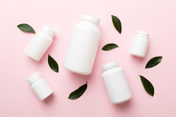 supplement pills with medicine bottle health care and medical top view. Vitamin tablets. Top view mockup bottle for pills and vitamins with green leaves, natural organic bio supplement, copy space