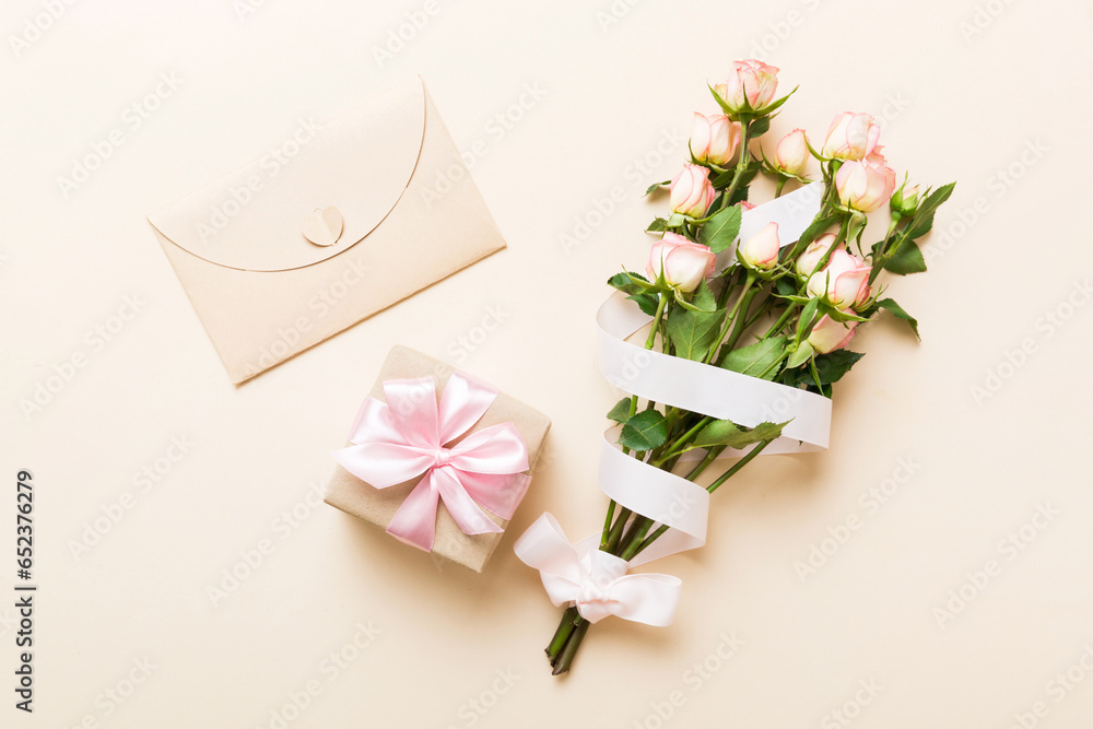 Wall mural greeting card mockup with copy space, pink ribbon and roses flowers on colored table background. fla