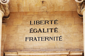 The famous French motto "Liberté, Égalité, Fraternité" in English "liberty, equality, fraternity" on the facade of the University of Paris, Faculty of Law. Paris, France