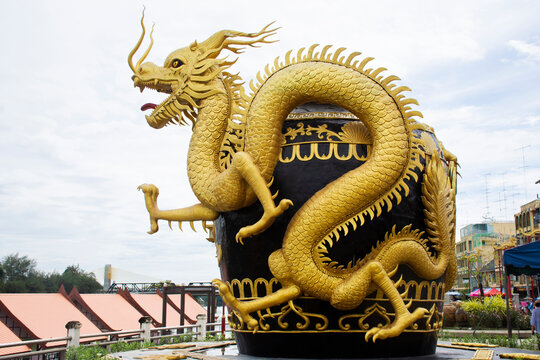 Symbol of Rat Buri city glazed water jar and sculpture carving art gold dragon riverside Mae Klong river for thai people travelers travel visit take photo at old town market in Ratchaburi, Thailand