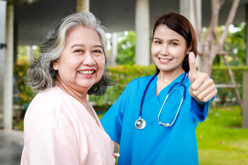 Portrait of an elderly female patient and a surgeon, both smiling brightly, standing outside a building. Medical services in hospitals. health insurance