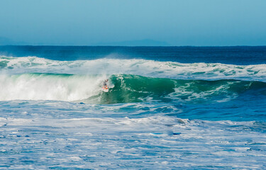 Surfer in a barrel falling under the force of the waves