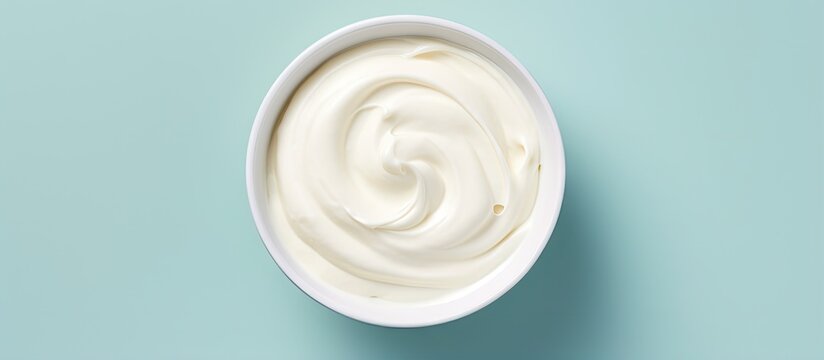 A isolated pastel background Copy space showcases a bowl of sour cream from above