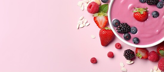 A delectable and healthy pink berry smoothie in a bowl seen from above against a isolated pastel background Copy space - obrazy, fototapety, plakaty