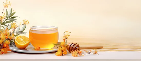 Fotobehang Tea made from sea buckthorn with added honey and lemon isolated pastel background Copy space © vxnaghiyev