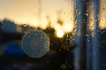 decorative snowflake with raindrops on the window