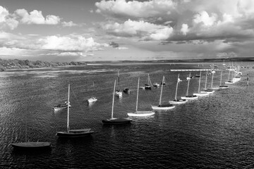 Looking out over the harbour with boats in black and white