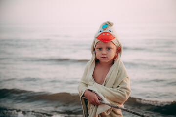 Blonde man on the beach, wearing clothes, making eye contact. Blond man on beach, looking at...