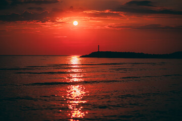 Dark red sunset by the sea. Sunset with pier background. Soft selective focus