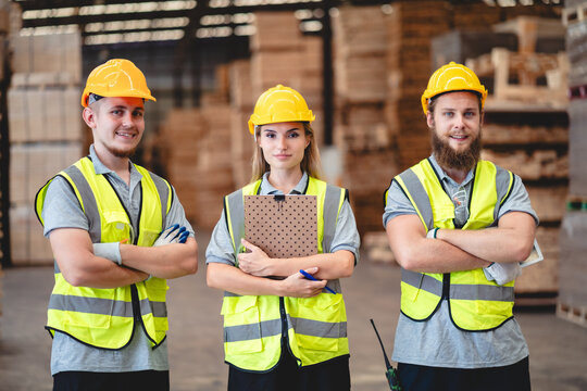 Warehouse worker logistic team wearing hard hat working in aisle between tall racks with packed goods warehouse for industry business of import, export delivery to global market, shipping management