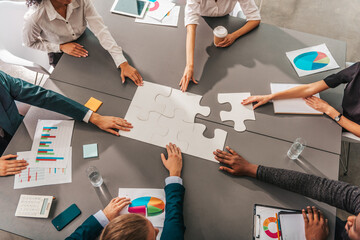 Businessmen working together to build a puzzle as teamwork, partnership and integration concept