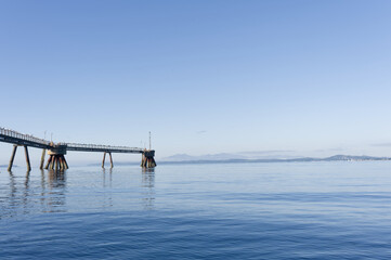 Old derelict wooden jetty pier in sea at Inverkip power station