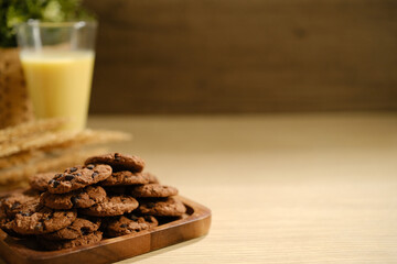 Homemade Chocolate Chip Cookies above Wooden Table, Served with a Bottle of Milk. Bakery Concept with Copy Space for Text