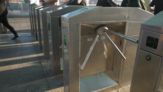 Close up of people go through turnstiles at day on the tram metro station. Transport infrastructure of the large city