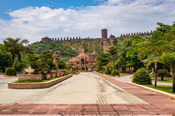 artistic carved red stone jain temple with bright blue sky at morning from unique angle