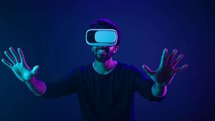 Cyber space gamer male Arabian man in VR glasses excited playing experience metaverse virtual...
