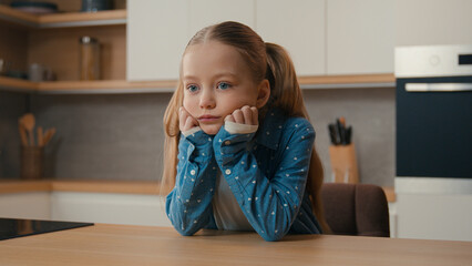 Moving camera sad little offended Caucasian child girl at kitchen boring stressed need parents help...