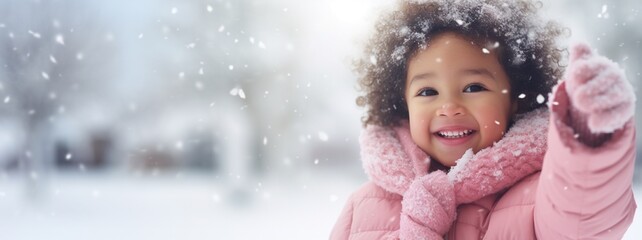 Cute beautiful girl in pink coat playing with snow outdoor in cold winter morning, with copy space, blurred snowy forest background, Winter holidays, Christmas trip concept.
