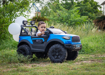 isolated cute toddler with innocent facial expression at toy car at outdoor from different angle