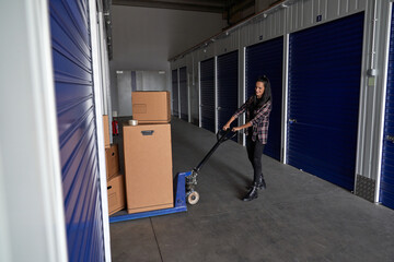 Woman rolling pallet truck with boxes