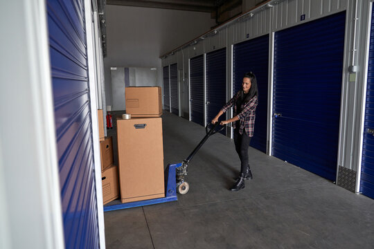 Woman rolling pallet truck with boxes