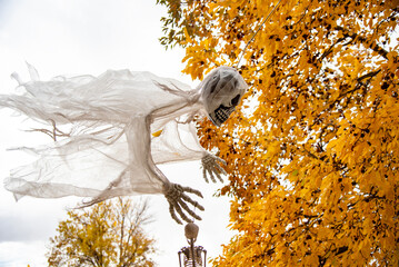Scary skeleton ghost flying through the sky with trees in background