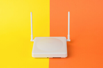 A router for distributing wifi signal on a yellow-orange background.