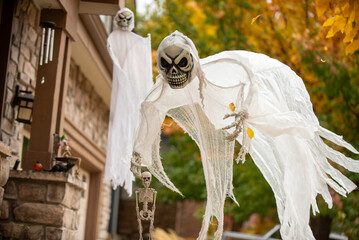 Scary flying skeleton ghost holding small skeleton