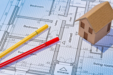 Building activity concept with residential building project printed on paper and building permit with home model