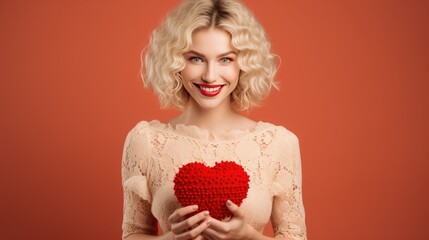A beautiful young woman holds a red heart in her hands. Love concept for Valentine's Day....