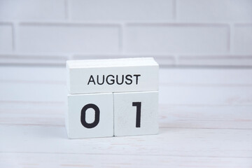 White wooden perpetual calendar showing the 1st of August.