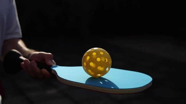Paddle sport player playing pickle ball in slow motion