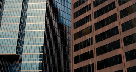 Fototapeta premium Downtown skyscraper extravaganza: breathtaking view from below focusing on towering windows of downtown. Capture the essence of downtown city life through reinforced concrete office buildings