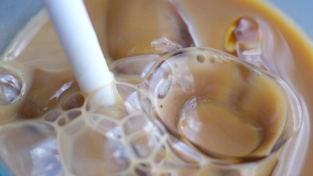 Ice latte with lactose-free milk oat or banana almond coconut milk in a delicious sweet drink close-up macro photography stir add ice. several videos