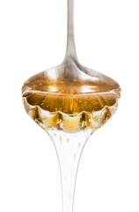 Honey dripping from silver spoon isolated on white background