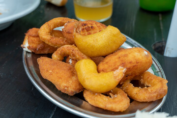 Ration of typical Spanish fried calamari rings shrimps croquettes