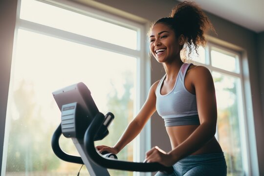 Young African American Woman During Workout On A Smart Exercise Bike At Home. Home Workout. A Scientific Approach To Training For Maximum Performance.