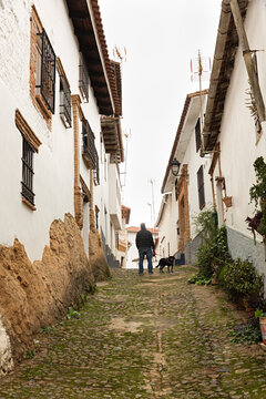 Hombre con su perro paseando por una calle de Valdlarco, Huelva.