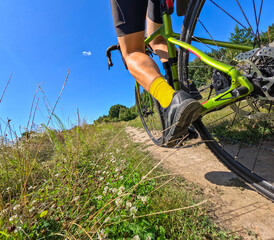 a bicycle in motion, a view of the wheel, on the background of a field with grass