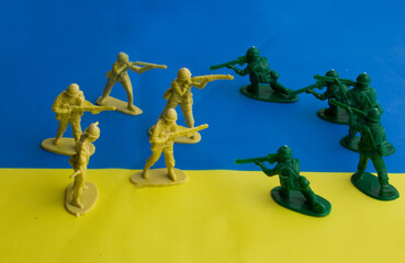 figurines of soldiers on the background of the Ukrainian flag