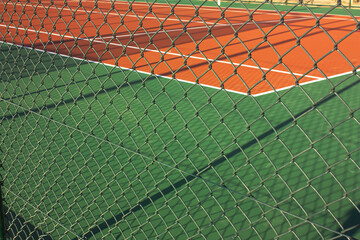 Photo of sports playing field surrounded by wire mesh.