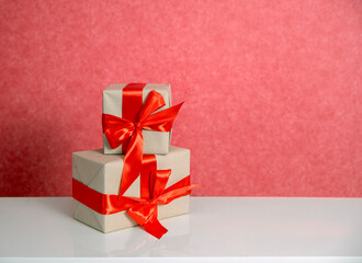 Gifts in boxes in craft paper with red ribbon