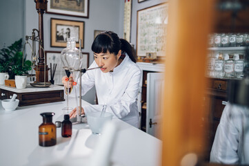 A focused Japanese pharmacist is making medicine by using a funnel