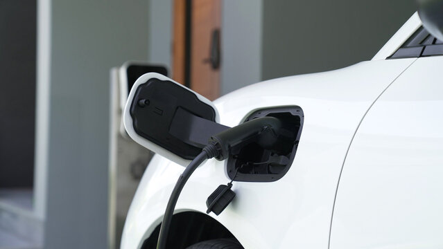 Home charging station providing sustainable, renewable source of power for electronic vehicle, EV cars at home for progressive modern lifestyle. Eco-friendly hybrid electro and petrol vehicle battery.