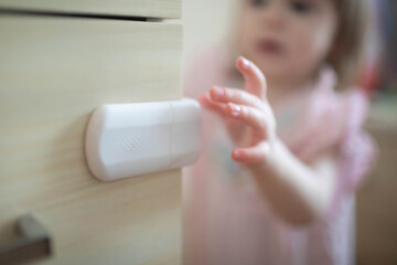 The child reaches out with his hand to the box on which the protection is installed.