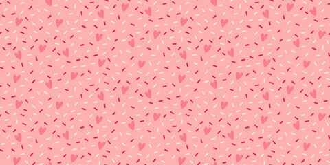Seamless pattern with decorative bright sprinkles texture on pink background.