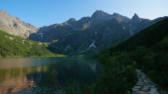 Famous mountains lake morskie oko or sea eye lake in summer evening. Beautiful sky sunlight above Tatras lake landscape. UNESCO's World Network of Reserves. Tatra national park, Poland.