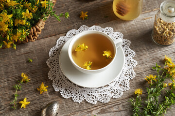 Fresh St. John's wort flowers in a white ceramic cup of tea