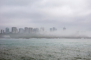 A foggy morning hides the buildings on the coast of the city of Mar del Plata