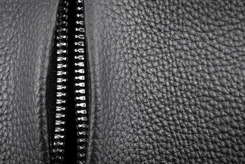 Close-up of a metal lock with a zipper on a leather bag. Clasp